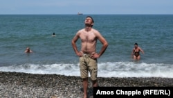 A Russian tourist soaks up the sun on a beach in Batumi amid reports of danger for Russians in Georgia. 