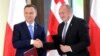 Georgian President Giorgi Margvelashvili (right) and Polish counterpart Andrzej Duda exchange documents during a joint press conference following their meeting in Tbilisi on May 30.