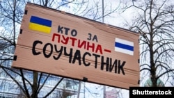 Плакат «Кто за Путина, тот пособник» на демонстрации против войны России в Украине. Ганновер, Германия, 9 апреля 2022 года