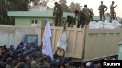 Afghan National Army troops distribute aid to the civilians of Kunduz on October 14.