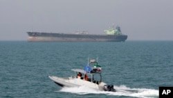 An Iranian Revolutionary Guard speedboat moves in the Persian Gulf while an oil tanker is seen in background. (file photo)