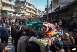 Relatives and neighbors attend the funeral procession for four Syrian security force members killed in clashes with loyalists of ousted President Bashar al-Assad in coastal Syria on March 8.