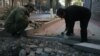 Two men repair a sidewalk in Tskhinvali, in South Ossetia.