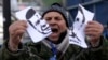 A protester tears a portrait of President Viktor Yanukovych.