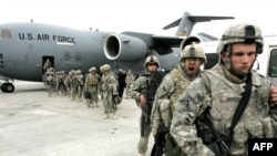 US soldiers leave a plane at Manas air field after arriving from Afghanistan