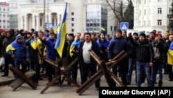 Жители Херсона стоят перед военными России во время митинга против российской оккупации. 7 марта 2022 года. Фото: AP