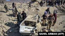 Taliban forces inspect a damaged car two days after air strikes by Pakistan in the Barmal district of eastern Afghanistan's Paktika Province on December 26.