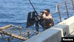 A gunner scans the sea aboard a U.S. ship in the Strait of Hormuz. (file photo)