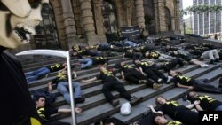 As part of a commemorative demonstration, activists from the environmental group Greenpeace lie on the stairs of the municipal theatre in the Brazilian city of Goiania, where a notorious radioactive accident resulted in the deaths of four people and affected thousands of others nearly 30 years ago. (file photo)