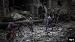 Syrian boys run past a destroyed field hospital in the rebel-held area of Douma, on the outskirts of Damascus, on October 29.