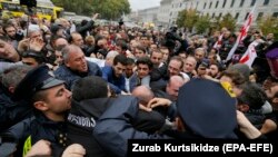 Opposition supporters clash with police in front of the Tbilisi city council during a protest rally in Tbilisi on October 10.