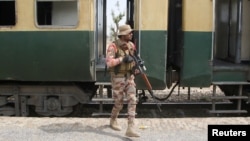 A Pakistan Army soldier stands guard next to a rescue train at the railway station in Mushkaf, Balochistan, on March 12 after an attack by separatist militants the day before. 