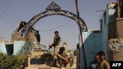 Afghan security forces stand guard at the main gate of the city's prison, after retaking Kunduz from the Taliban, on October 8.