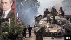 A Russian tank passes by a huge portrait of Vladimir Putin as it passes through Tskhinvali, South Ossetia, in August 2008.