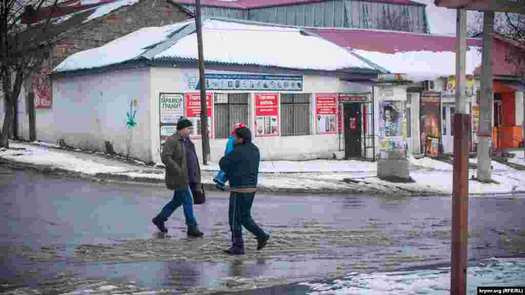 В ветхих зданиях старой части города открываются новые магазины, а люди по-прежнему спешат по делам