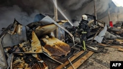 A Ukrainian rescue worker tries to extinguish a fire in a building destroyed in a Russian drone attack on Bohodukhiv in Ukraine's Kharkiv region on March 8.