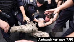 Russian police officers detain a protester during a march to protest against the alleged impunity of law enforcement agencies in central Moscow on June 12.