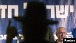 The silhouette of an ultra-Orthodox Jew at a convention with Prime Minister Benjamin Netanyahu (right) in Netanya, Israel, on January 13.